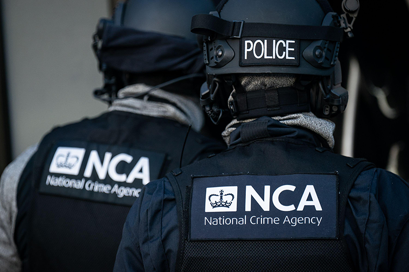 National Crime Agency and Police logos seen on the backs of agents in body armour and helmets.