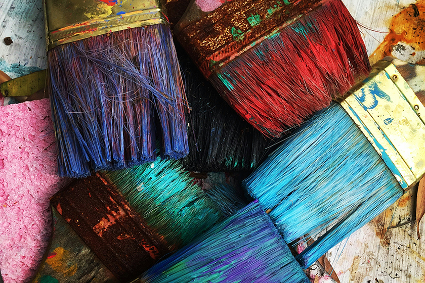 Paintbrushes, with different coloured paints on them. Closeup.